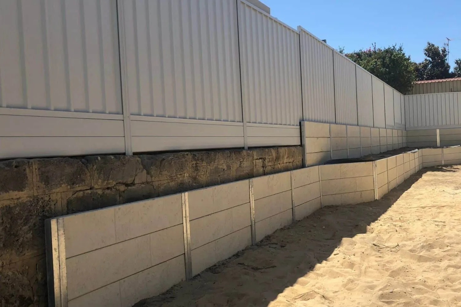 Concrete sleeper retaining wall along a driveway