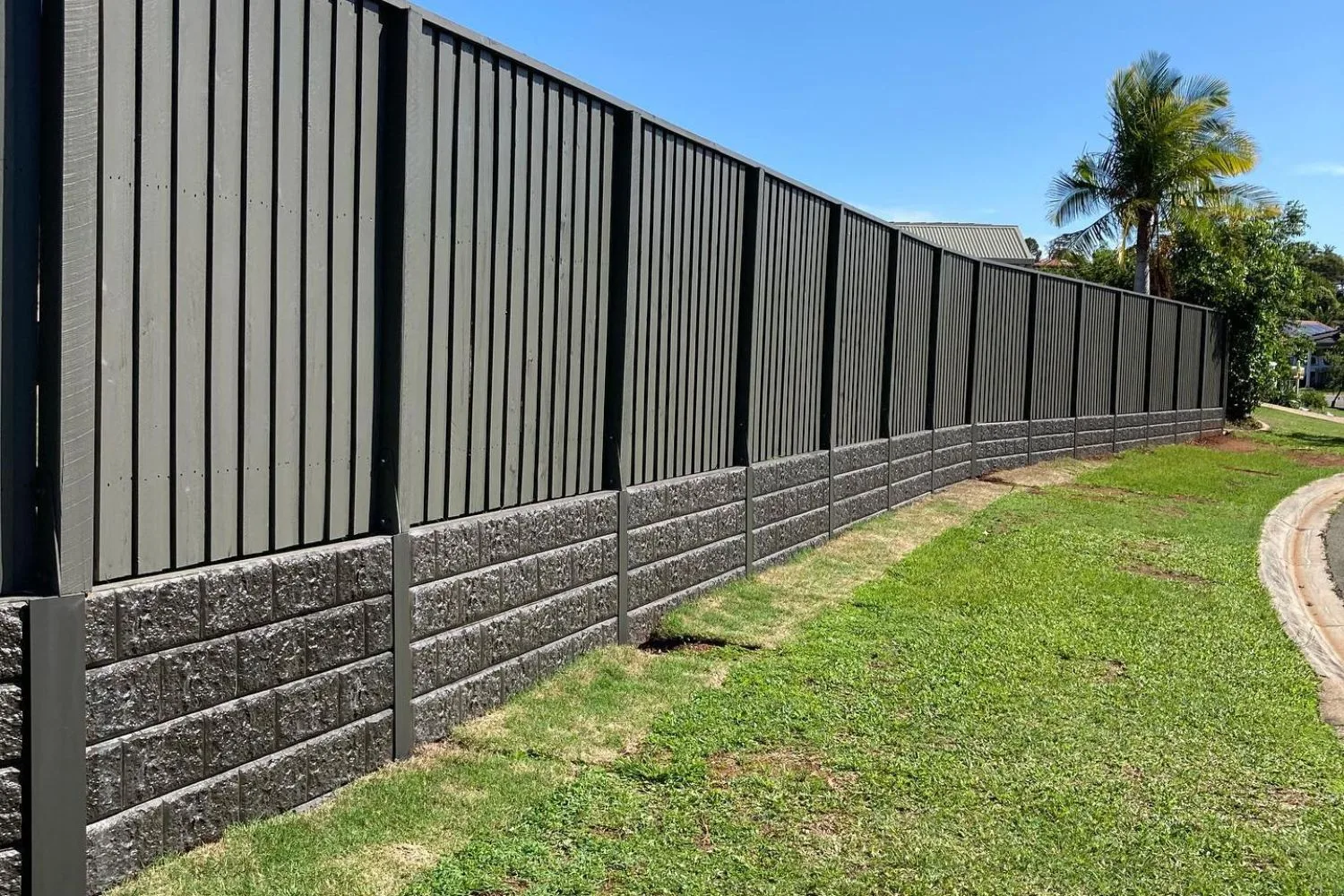 Concrete sleeper retaining wall along a driveway